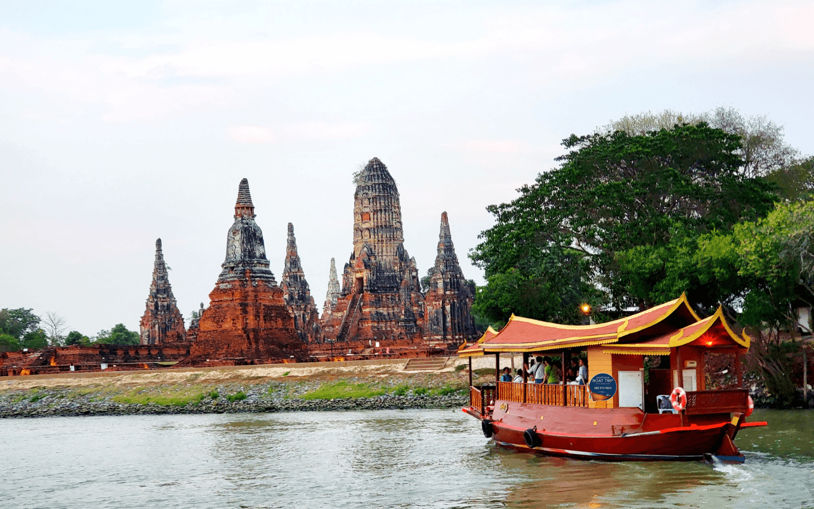 เรือไม้ทรงไทยล่องผ่านโบราณสถานอยุธยา